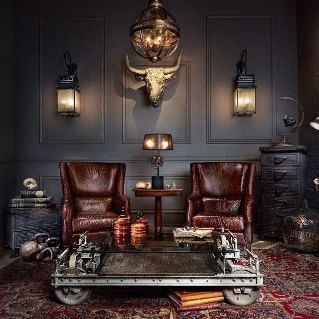 Two brown leather armchairs and an industrial metal coffee table in a man cave.