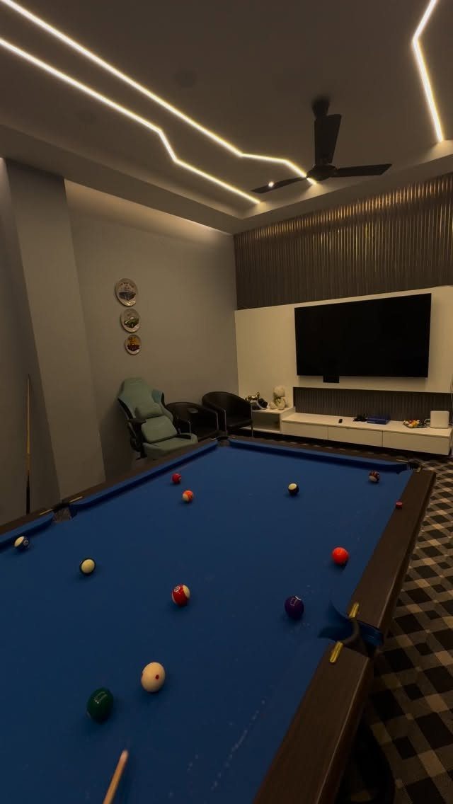 Blue pool table in a modern man cave with TV and LED lighting