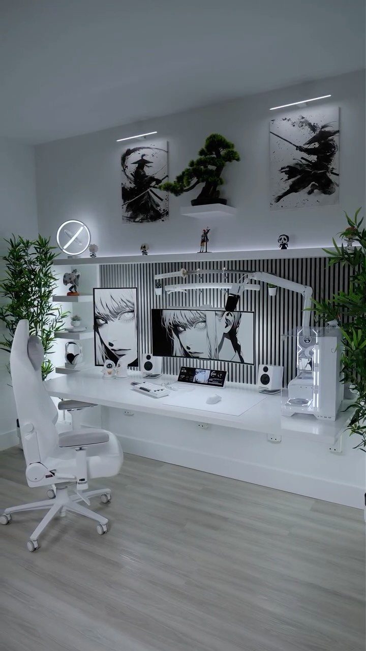 White gaming and work setup with ergonomic chair, wide monitor, and minimalist decor.