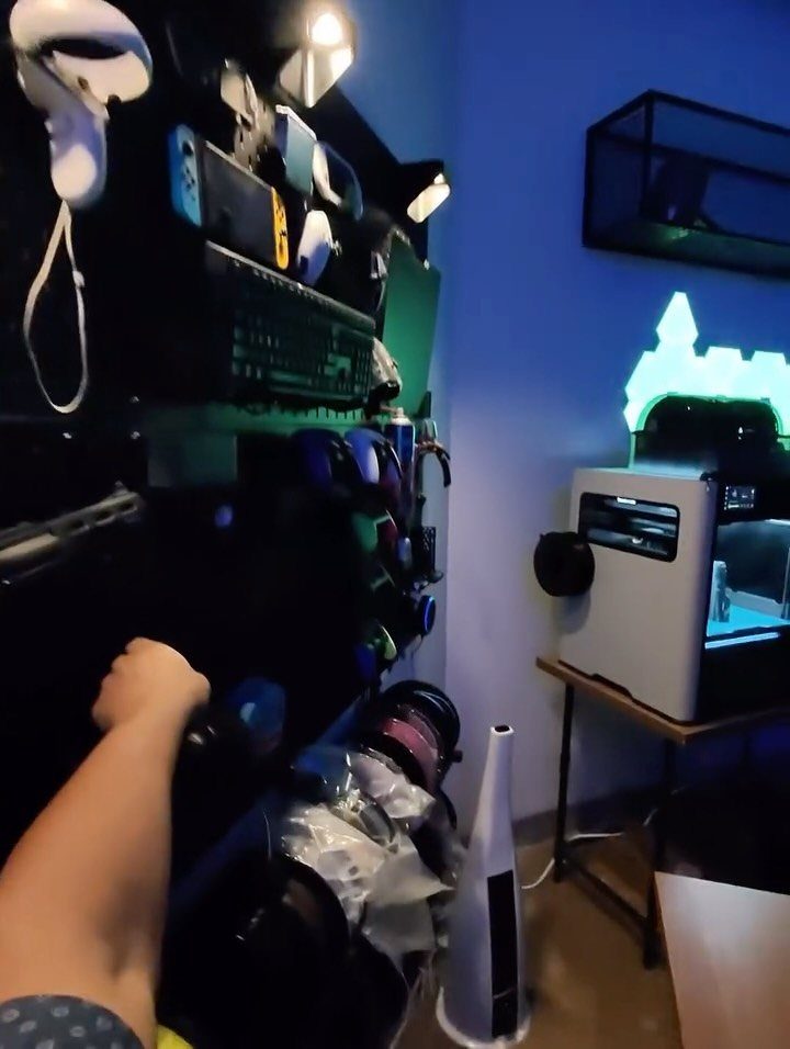 Gaming room setup with a white PC, VR headset, and blue ambient lighting.
