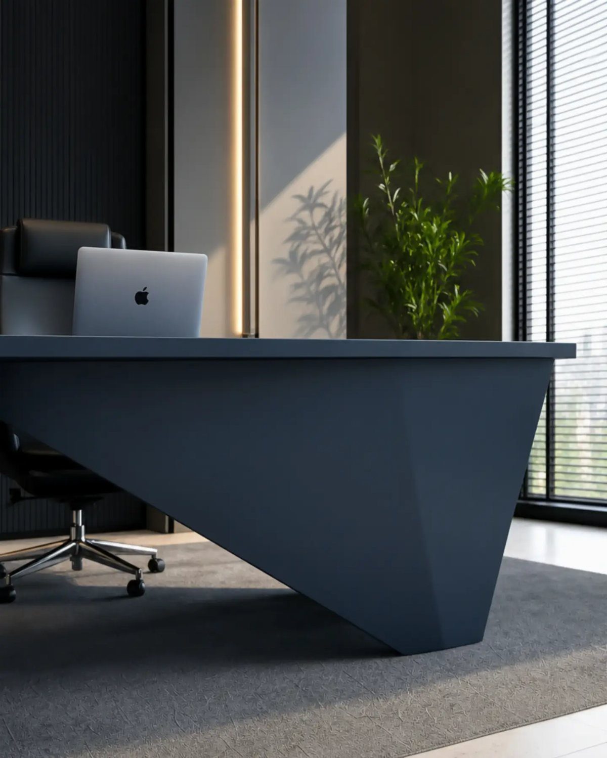 Dark grey geometric modern desk with a laptop and black leather office chair.