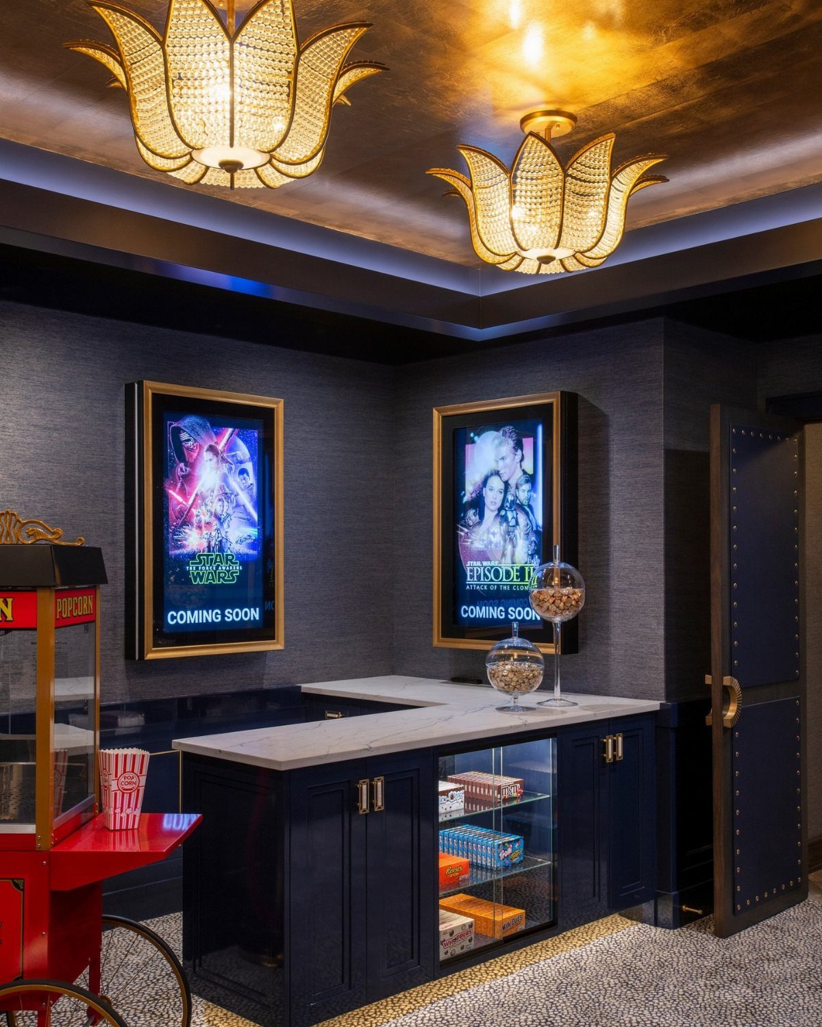 Home cinema lobby with movie posters, popcorn machine, and gold lotus ceiling lights.