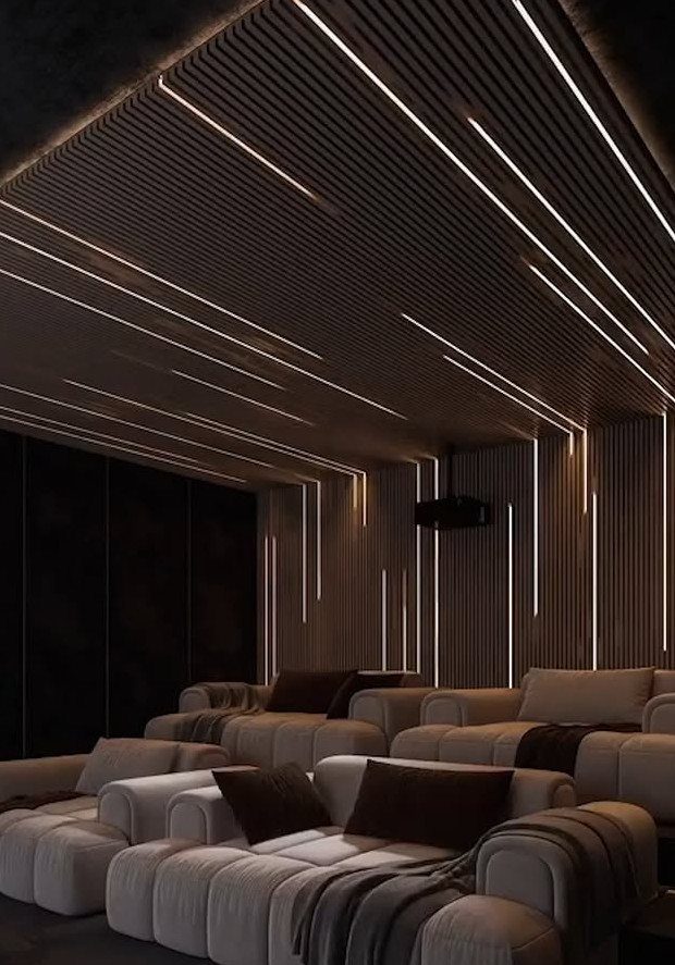 Modern home cinema room with grey reclining seats and linear LED ceiling lighting
