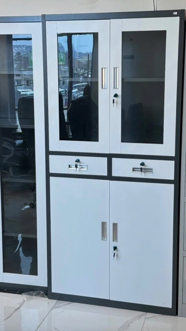White office storage cabinet with glass doors, drawers, and silver handles on white floor