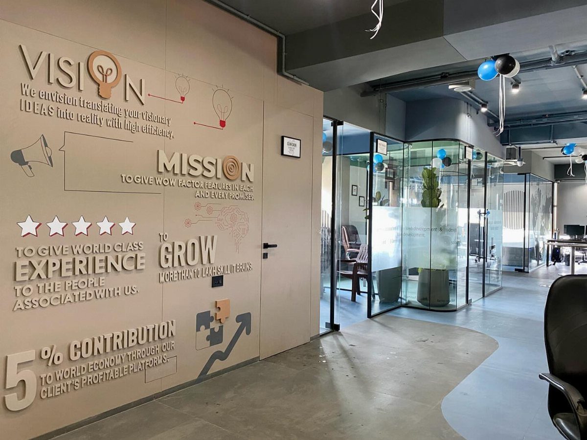 Office wall with 3D text displaying company vision and mission statements in a modern workspace.