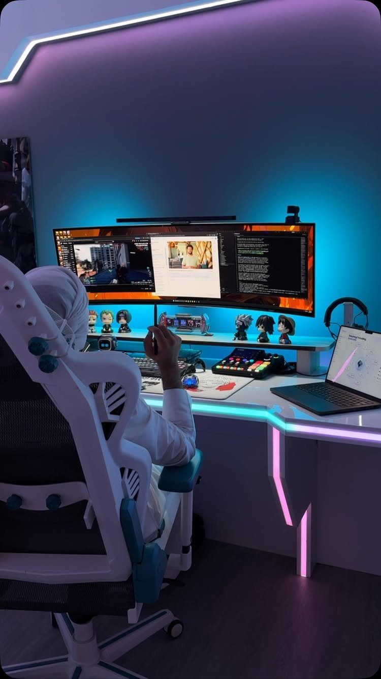Gaming setup with a wide curved monitor, RGB lighting, and white gaming chair.