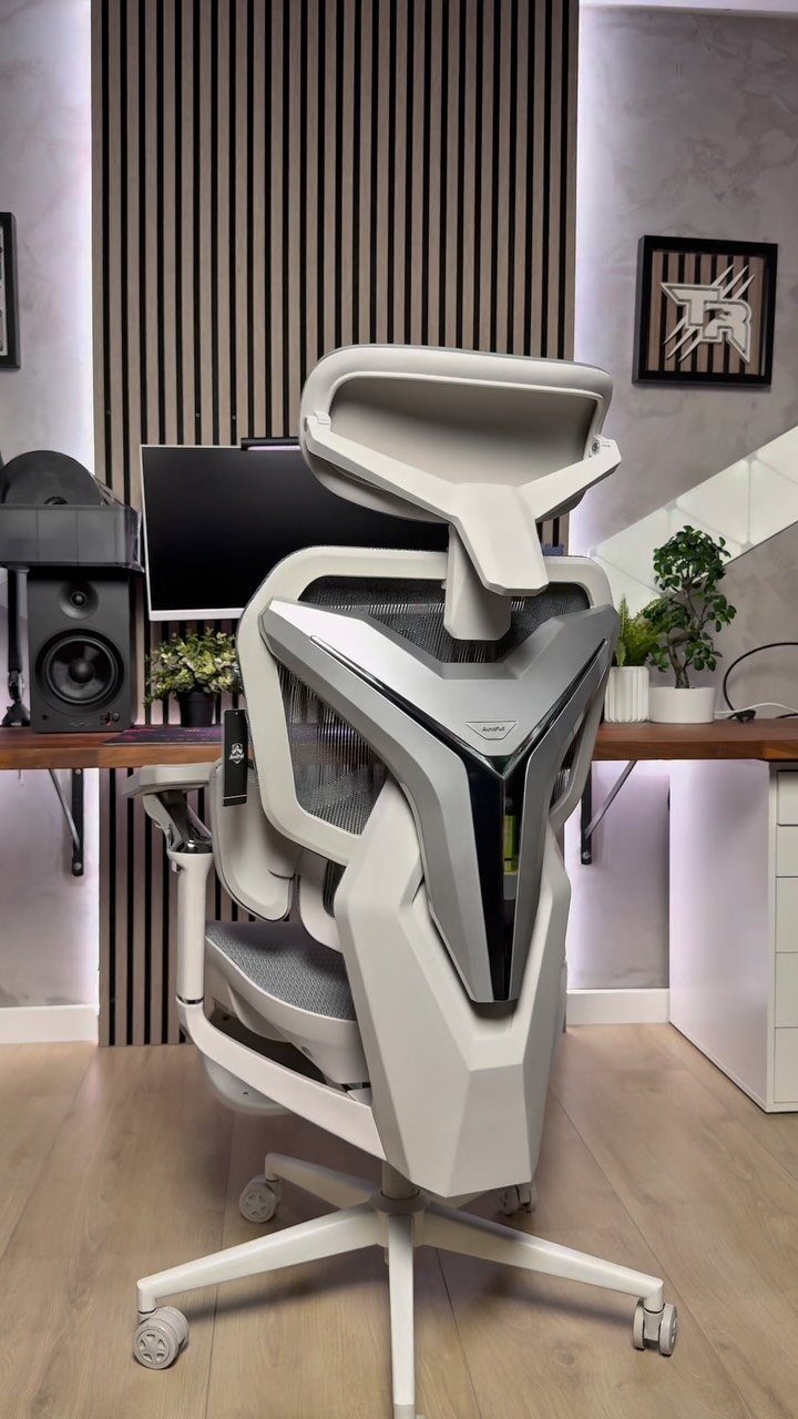 Futuristic white ergonomic gaming chair in a modern office setup with slatted walls.