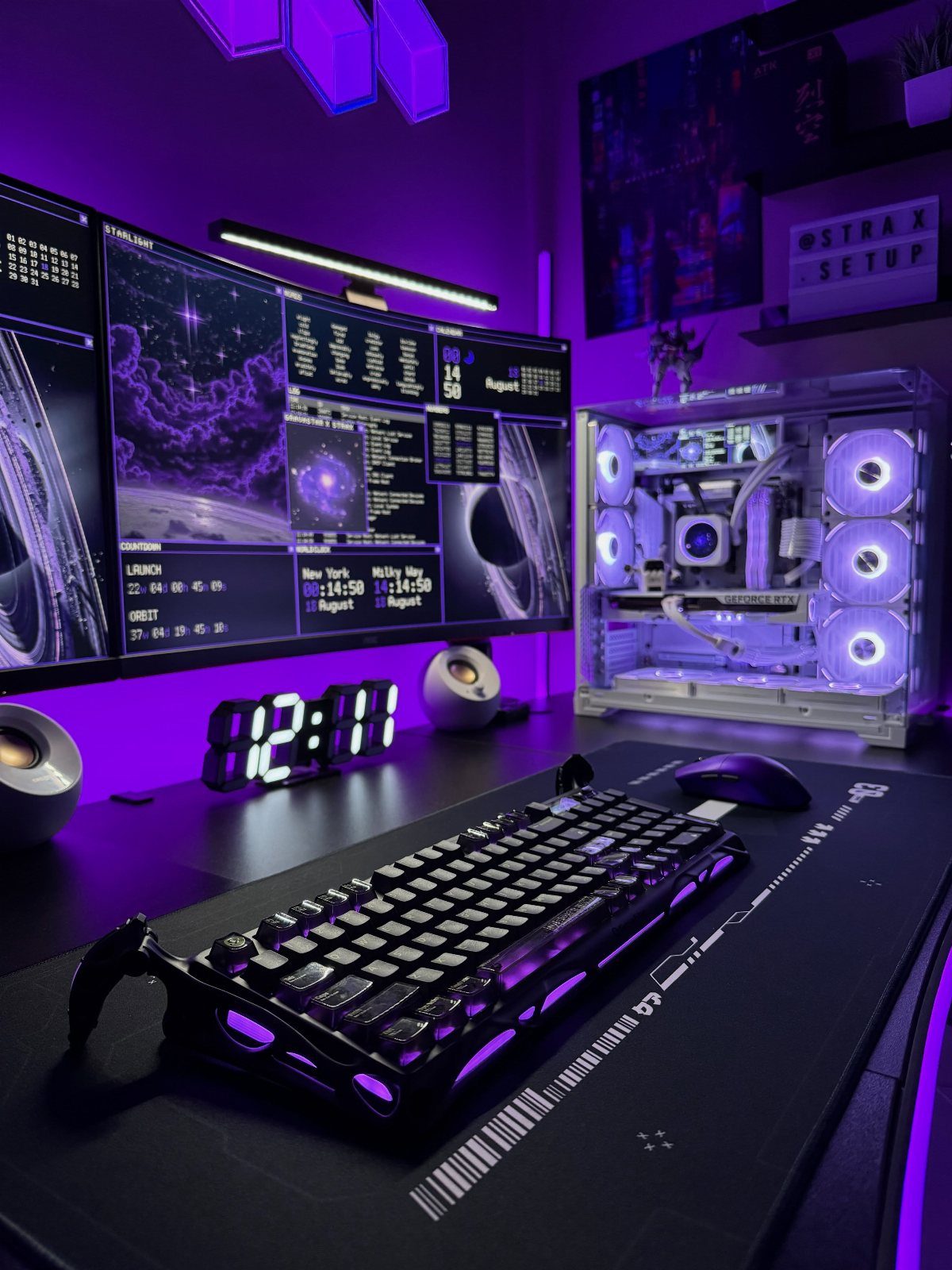 Gaming desk setup with purple lighting, space-themed monitor wallpaper, and glowing PC case.