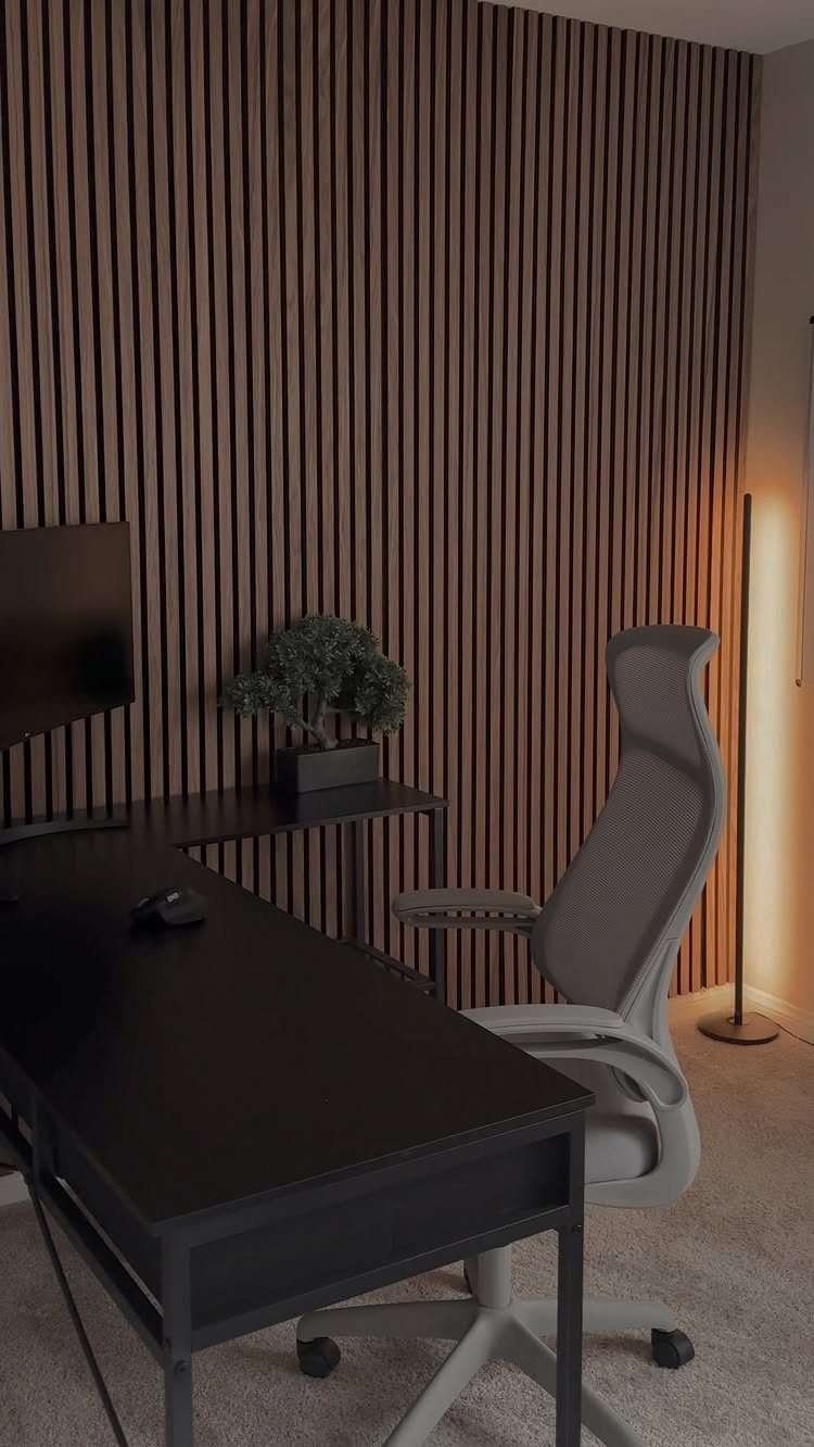 Home office with a black desk and a vertical wooden slat accent wall.