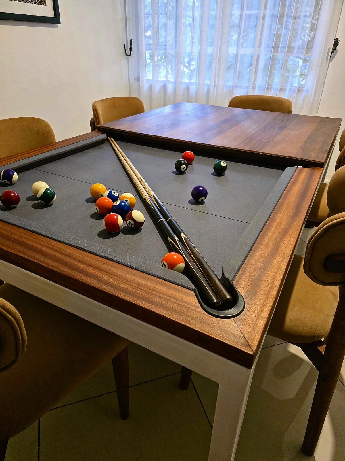 Convertible pool table with grey felt, billiard balls, and a wooden dining top.