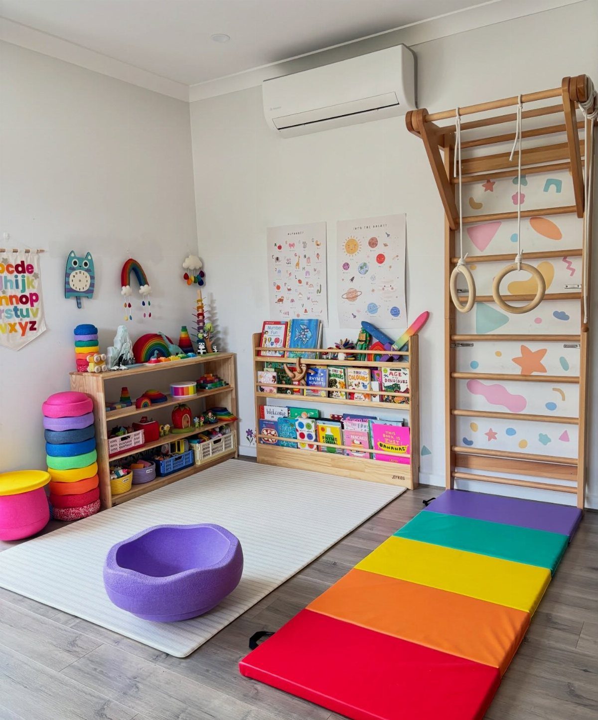 Children's playroom with wooden toy shelves, climbing frame, and rainbow gym mat.