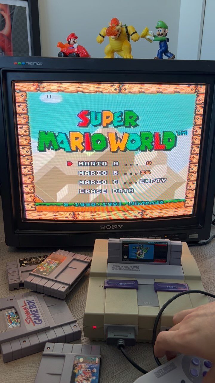 Sony CRT television playing Super Mario World with Super Nintendo console and cartridges.