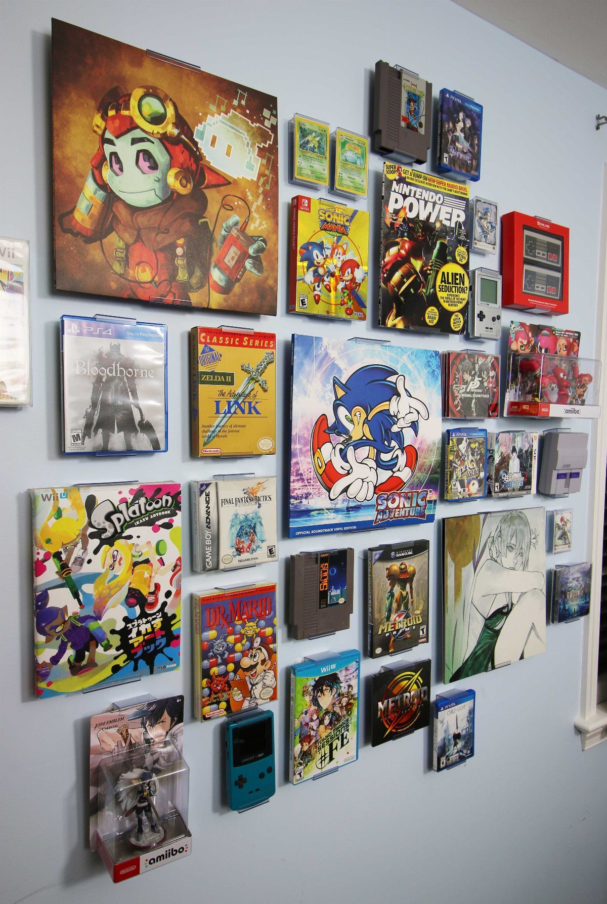 Video game cases and cartridges arranged as art on a light blue wall