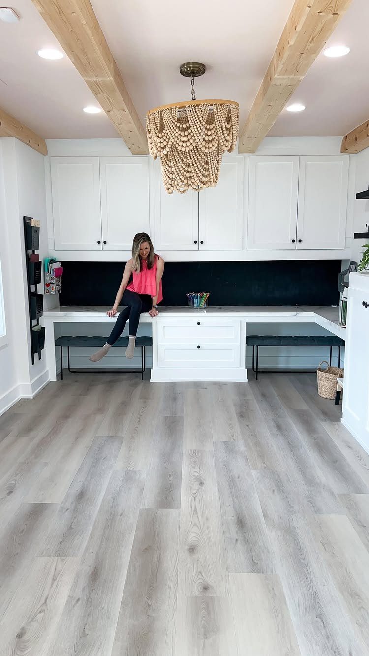 Grey wood-look vinyl plank flooring in a bright room with white cabinetry.
