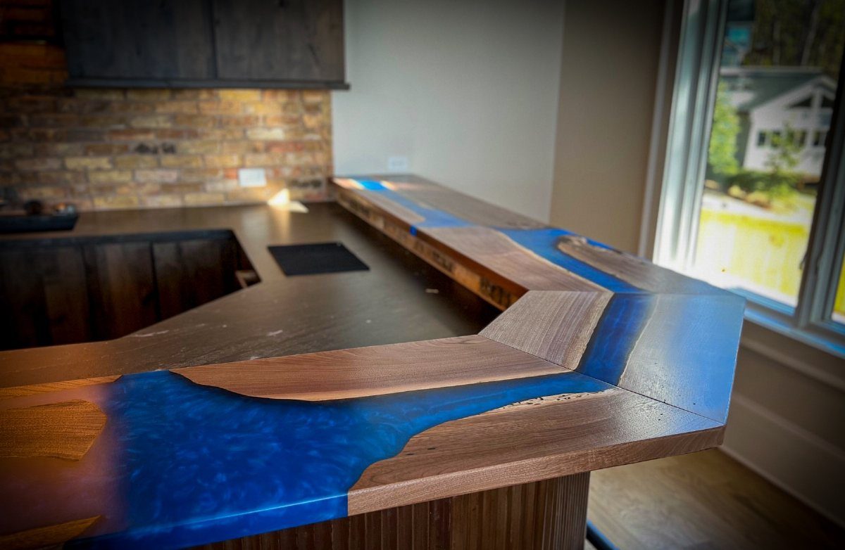 L-shaped wooden bar counter with a blue epoxy resin river inlay in basement