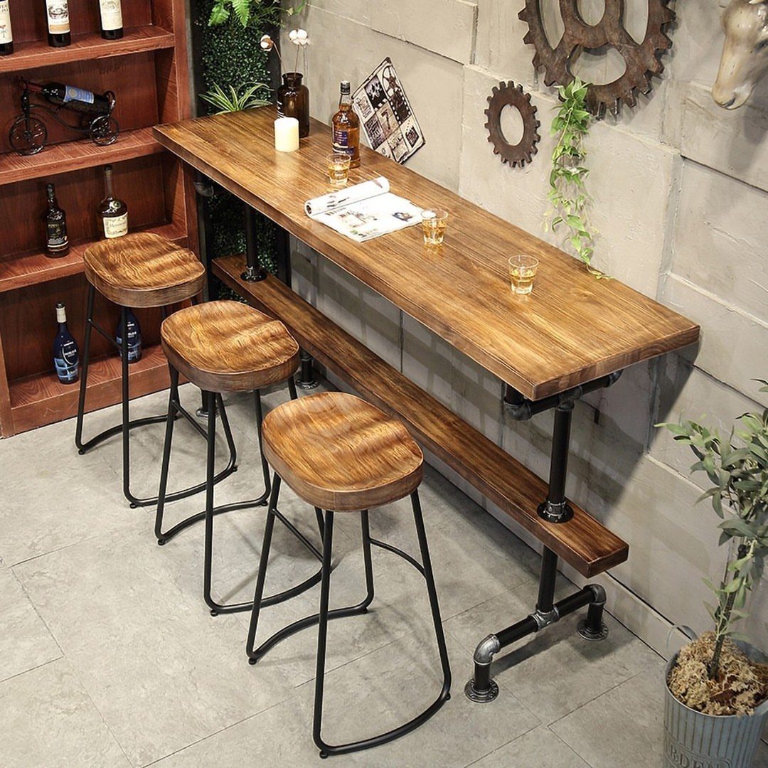 Wooden industrial bar table with pipe legs and three matching wooden stools.