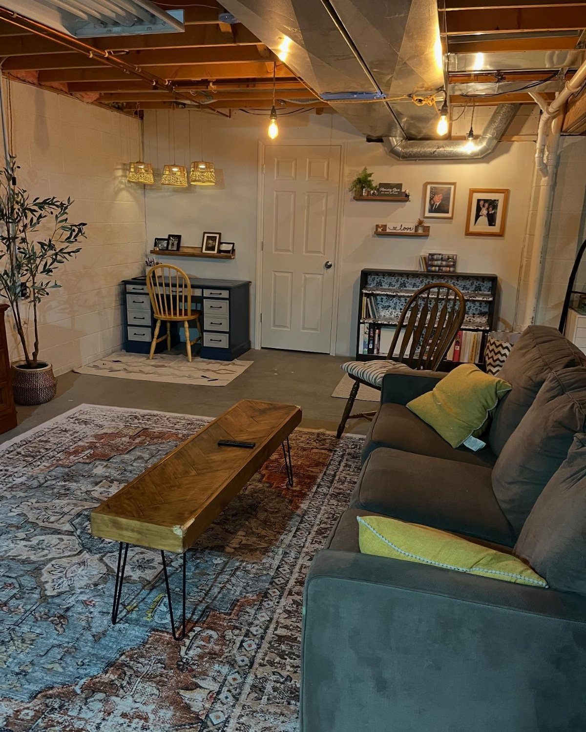 Small blue desk with yellow chair in a finished basement living area.