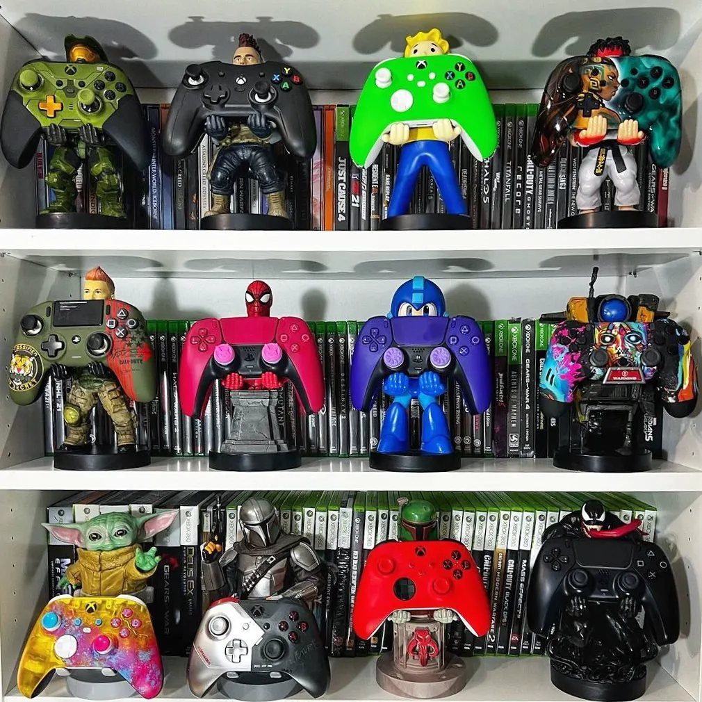 Custom painted gaming controllers as character figures displayed on shelves with game cases.