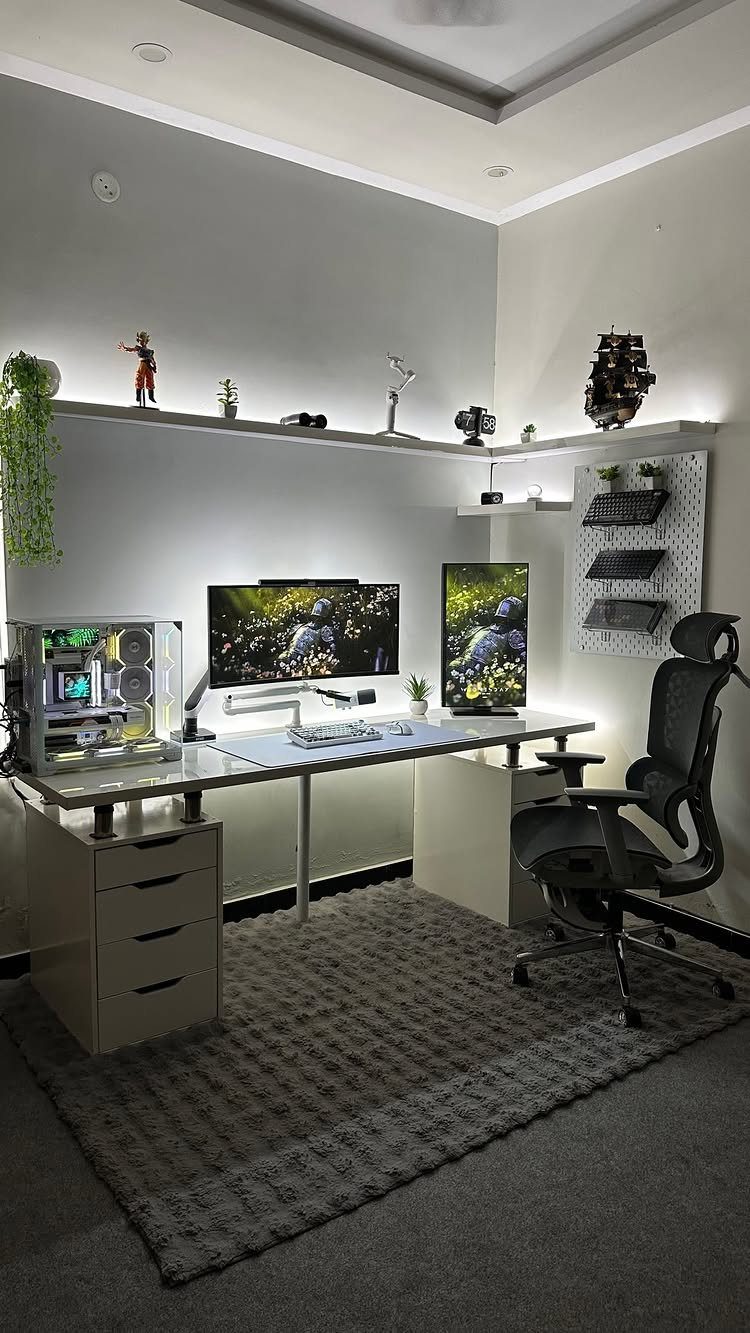 White gaming desk with dual monitors, PC tower, and ergonomic chair in grey room