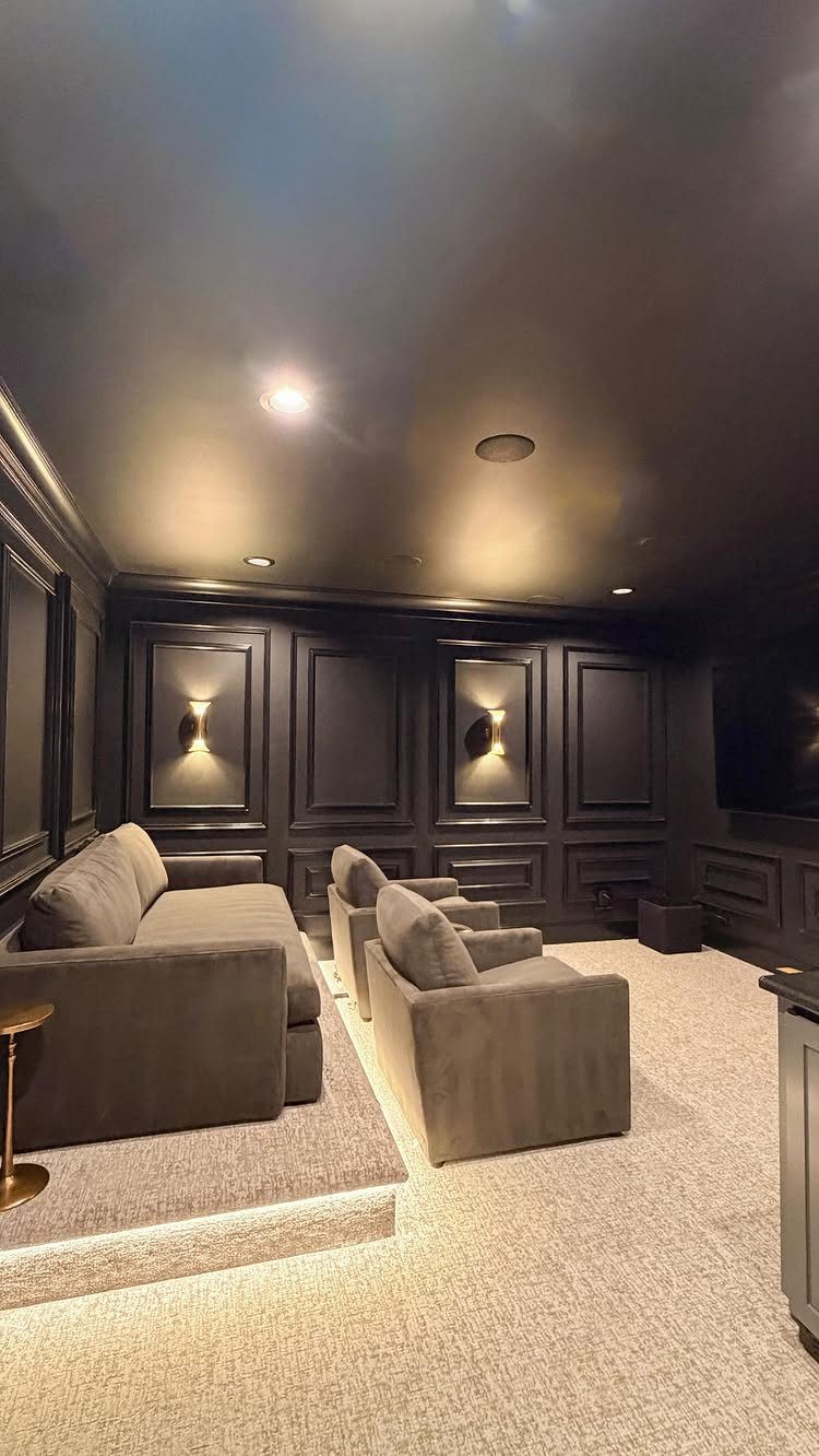 Dark charcoal grey paneled walls and ceiling in a luxury home cinema room.
