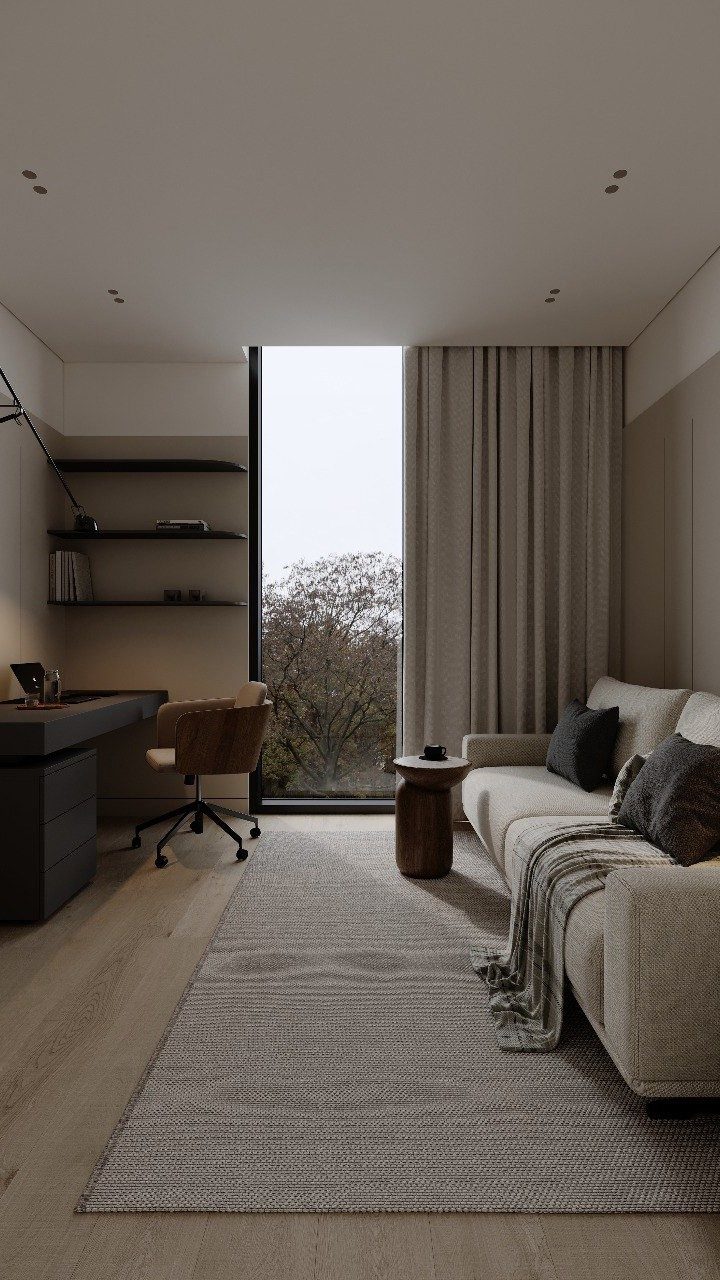 Minimalist home office layout with a dark desk, tan chair, and cozy sofa.