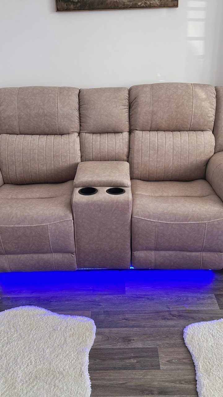 Beige reclining theater seats with a center console and blue under-glow LED lighting.