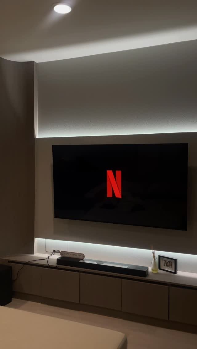 Flat-screen TV with Netflix logo and a slim black soundbar on a floating console.