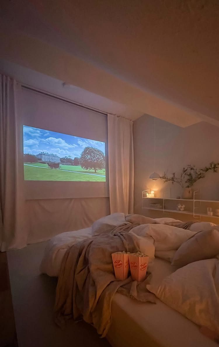 Pull-down projector screen in a bedroom with a bed and popcorn buckets.