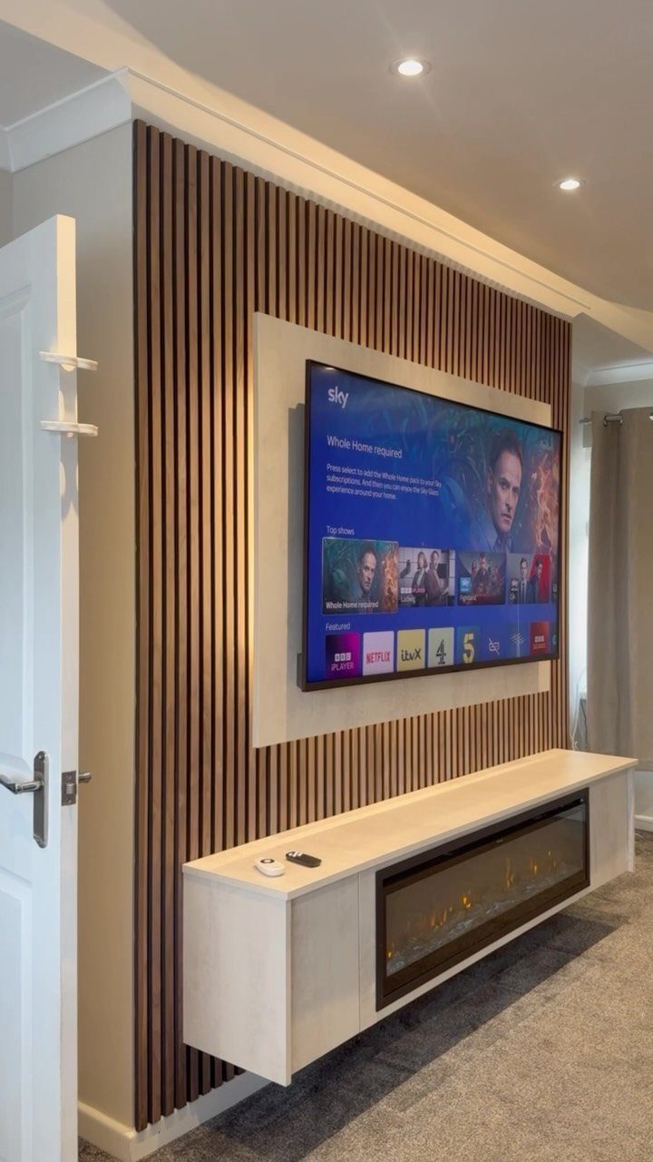Wall-mounted television on a wooden slat wall with a floating fireplace console below.