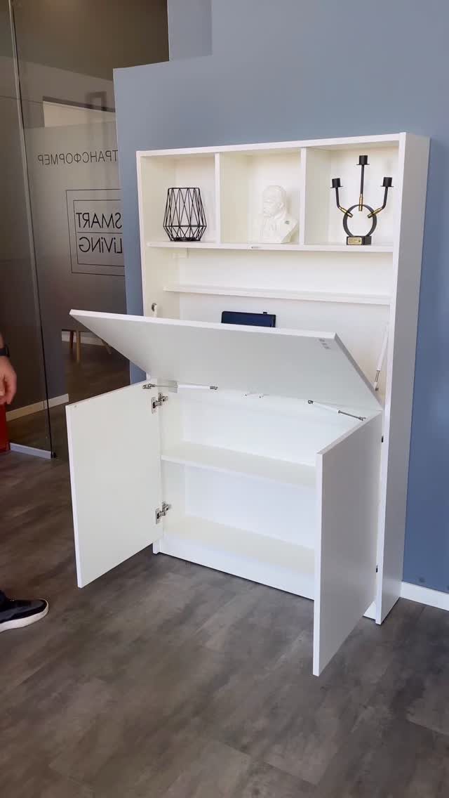 White wall unit with a fold-down desk surface and open storage shelving above.