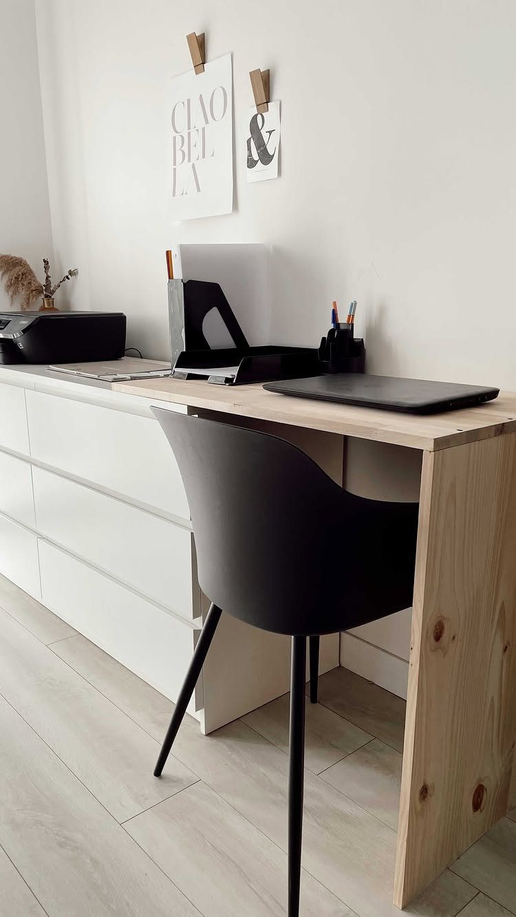 Light wood desk surface integrated with a white dresser for office storage.