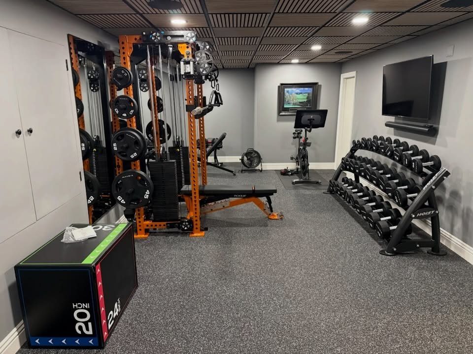 Home gym in a finished basement with weight machines, dumbbells, and exercise equipment.