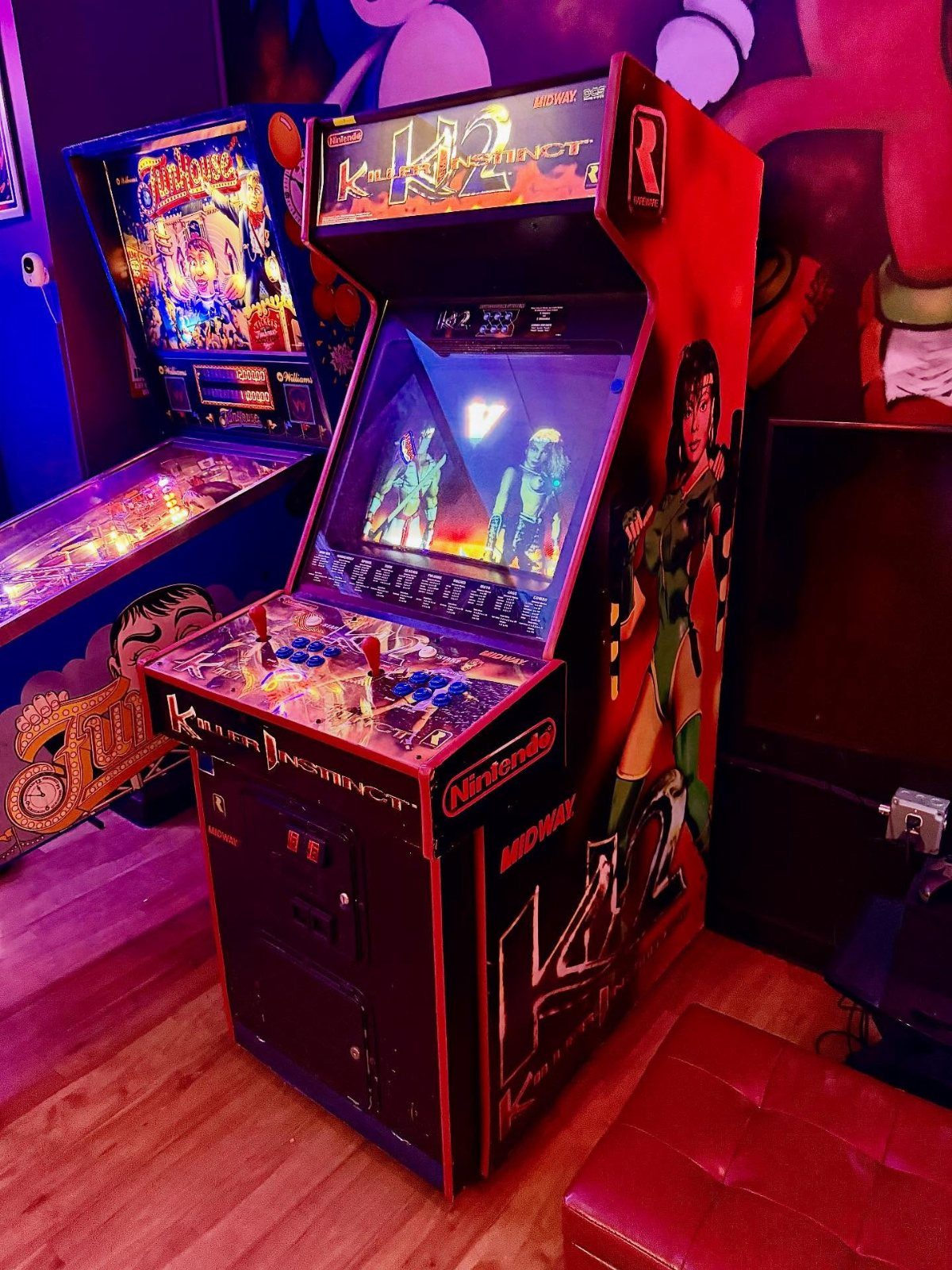Killer Instinct arcade machine and pinball machine in a red lit gaming room