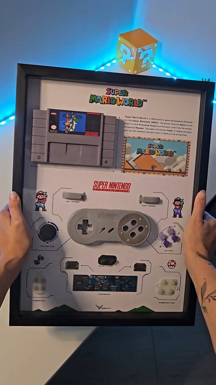 Framed shadow box displaying disassembled Super Nintendo parts and Super Mario World cartridge.