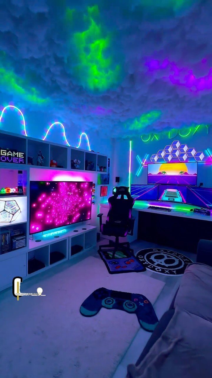 Gaming room with neon lighting, computer setup, large TV, and cloud ceiling.