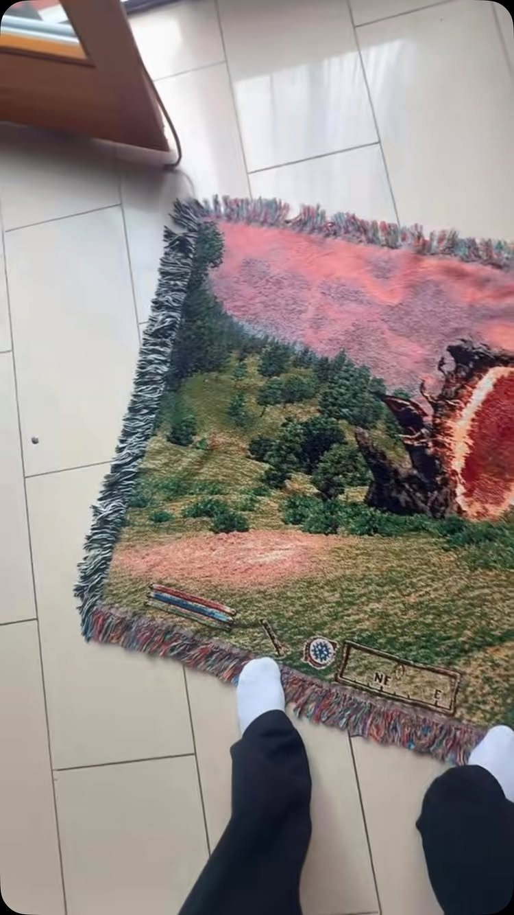Colorful gaming area rug with landscape art on a white tiled floor.