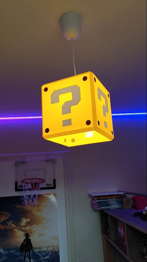 Yellow question mark block lamp hanging in a room with purple accent lighting.