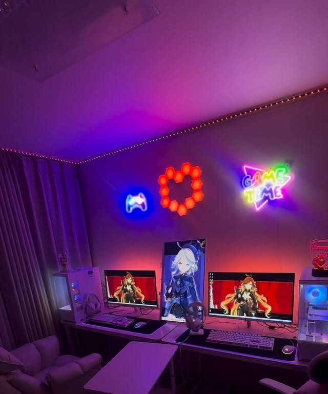 Two side-by-side gaming computer setups with neon wall signs and purple ambient lighting.
