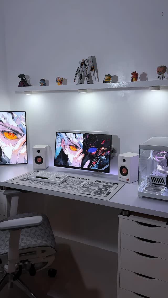 White gaming desk with monitors and a floating wall shelf displaying anime figurines.