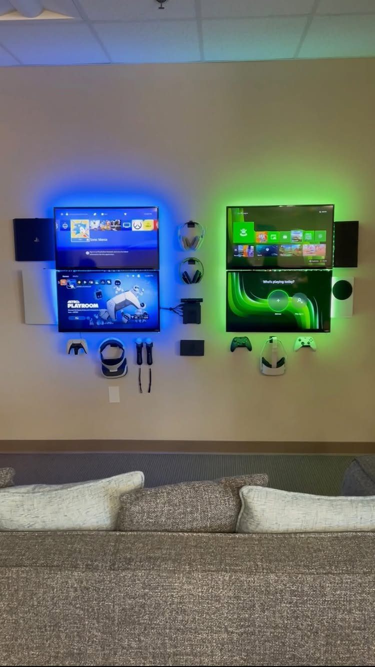Four wall-mounted gaming monitors with blue and green backlighting and gaming accessories.