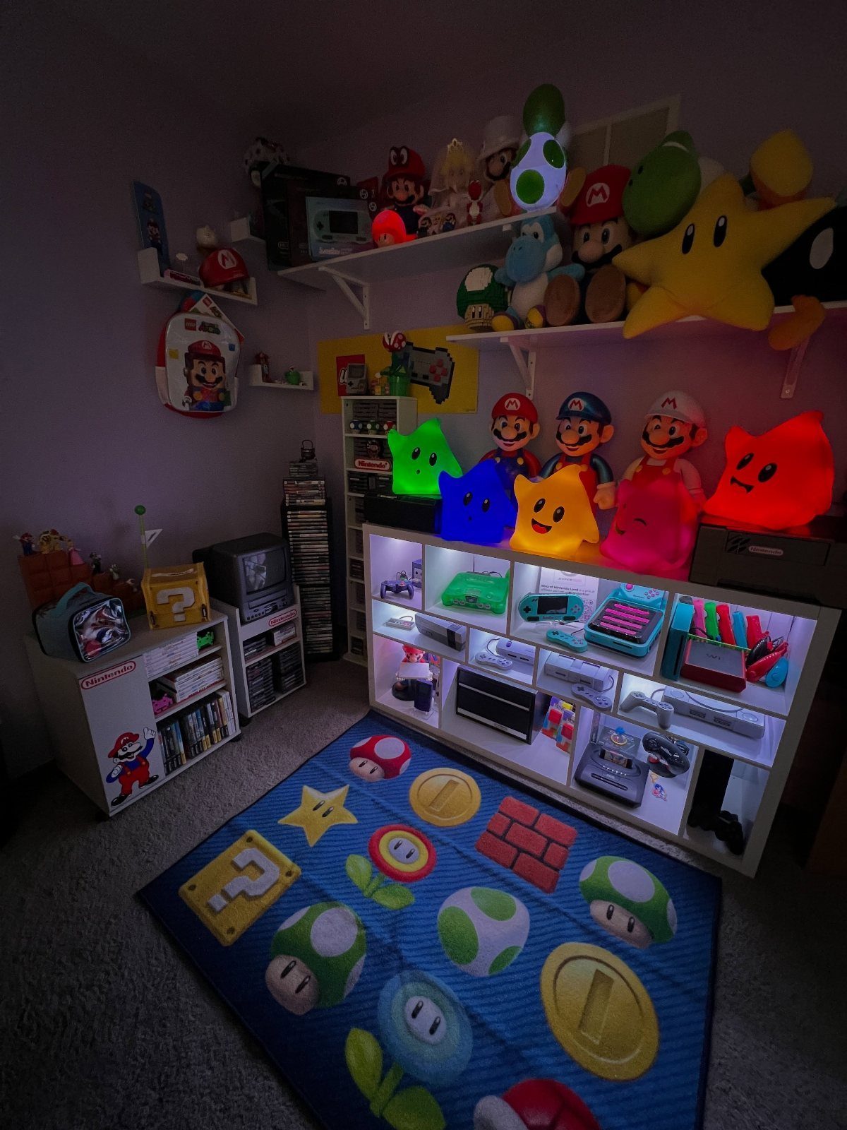 Nintendo themed gaming room with plush toys, consoles, and a Mario rug.