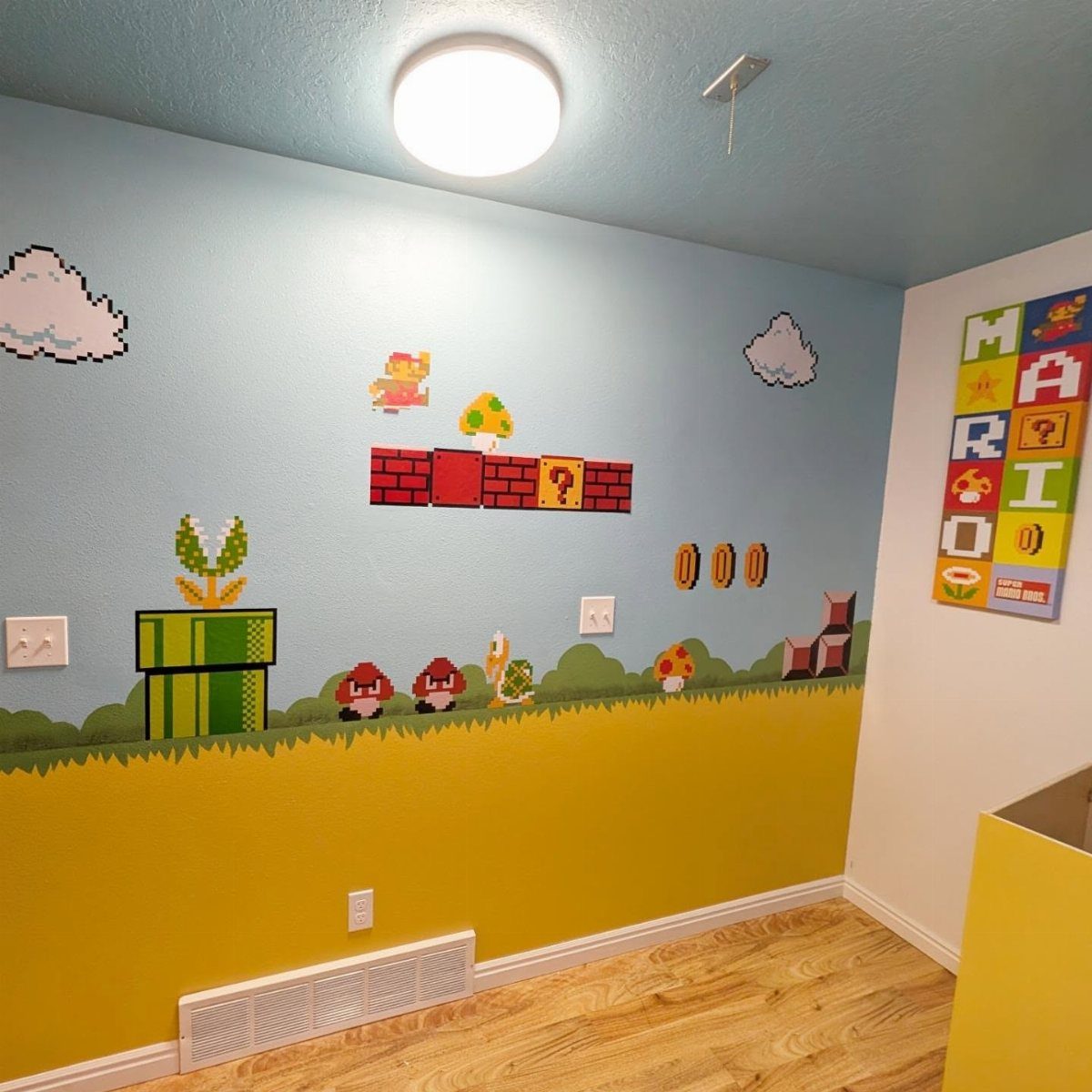 Pixelated Super Mario wall decals on a blue and yellow painted room wall.