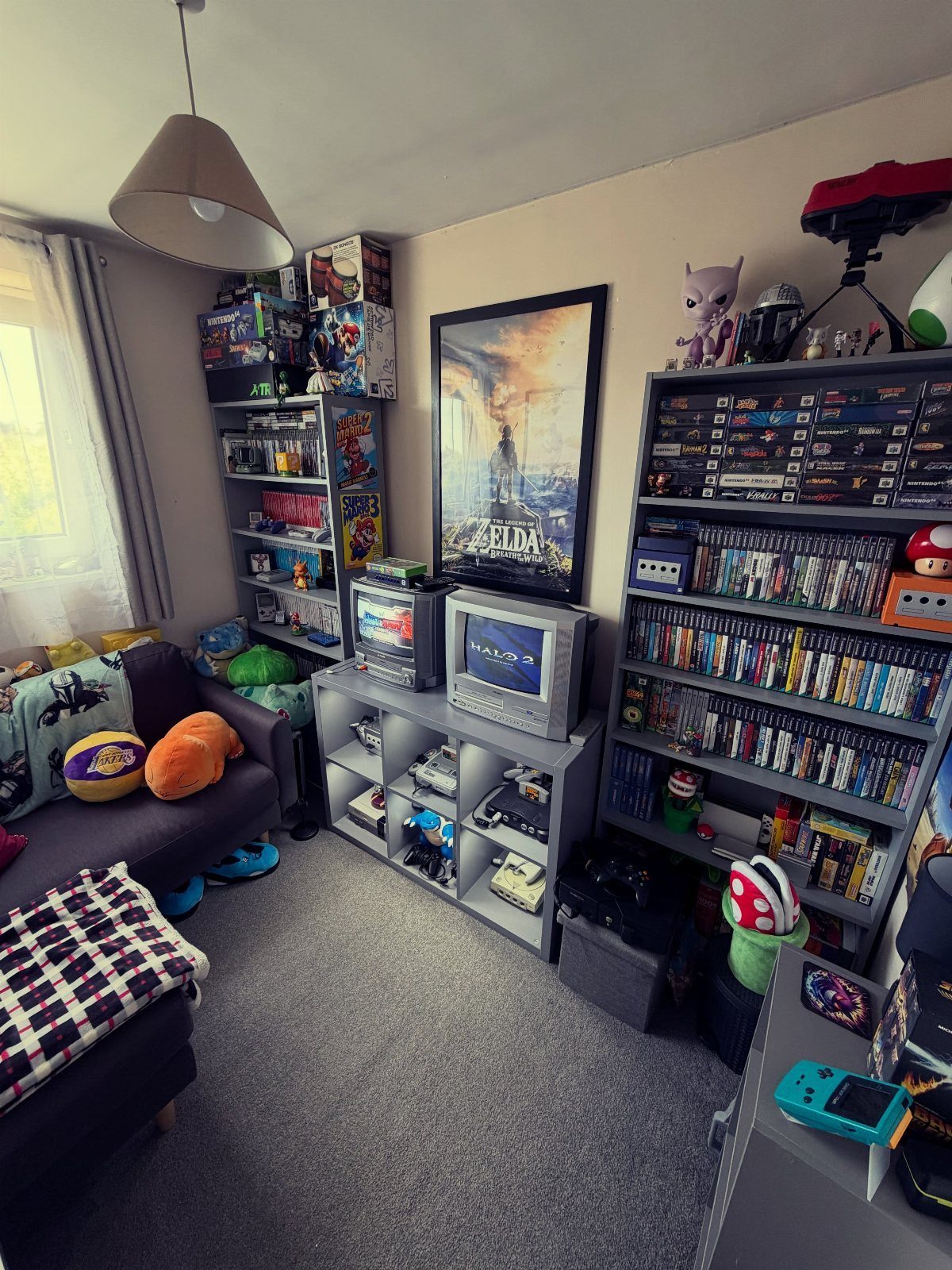 Gaming room with a Zelda poster, CRT television, and shelves of video games.