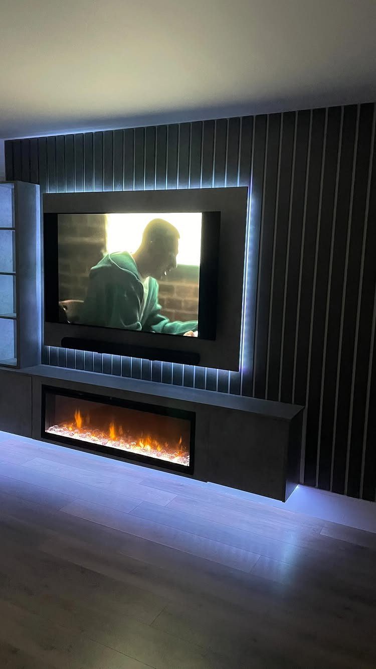 Wall-mounted TV with blue LED backlight and a floating console with integrated fireplace.